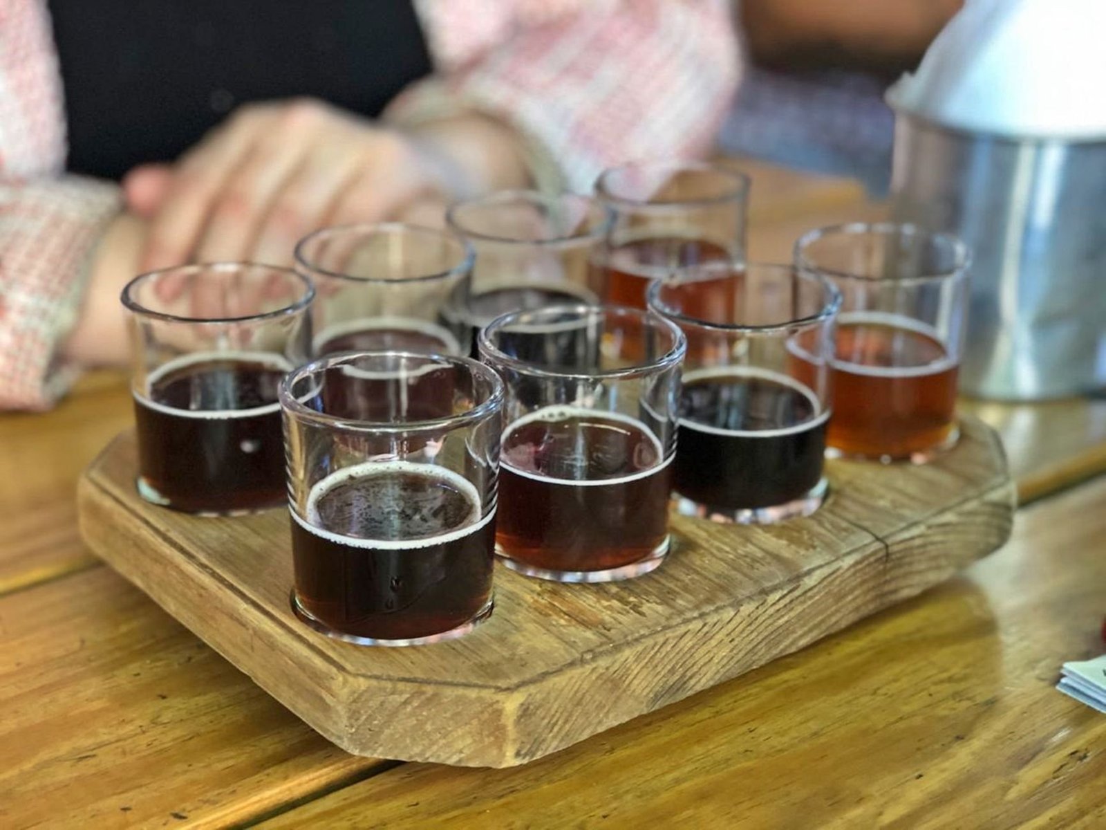 Cervejarias Artesanais em Gramado e Canela: onde provar 2 Seleção de cervejas artesanais em diferentes copos sobre tábua de madeira