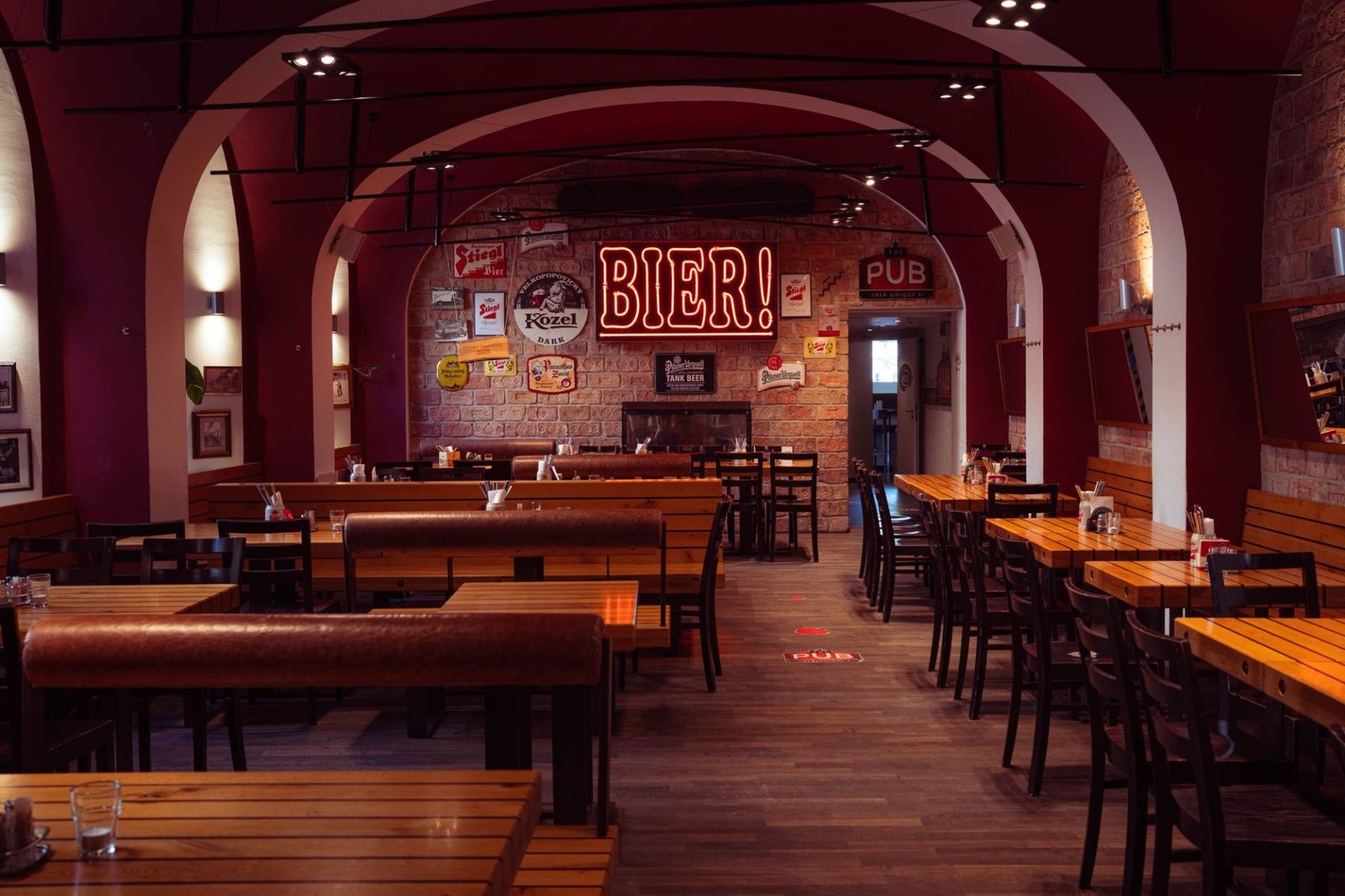 Cervejarias Artesanais em Gramado e Canela: onde provar 3 Interior aconchegante de pub europeu com mesas de madeira e iluminação quente
