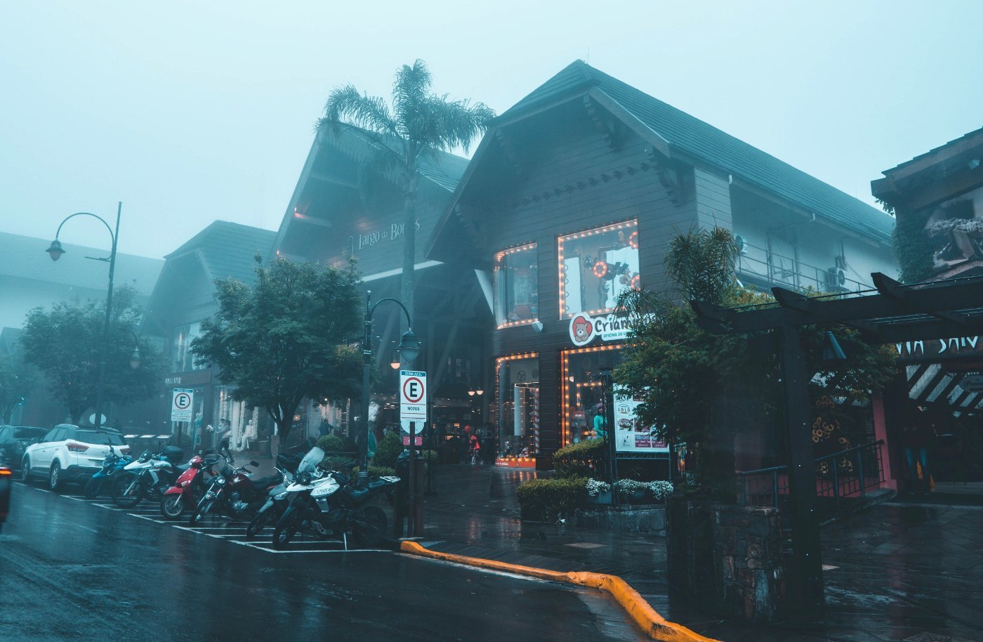 Gramado em Julho: Como é o Auge do Inverno na Serra 3 Rua de Gramado em dia chuvoso e enevoado no inverno, com lojas iluminadas