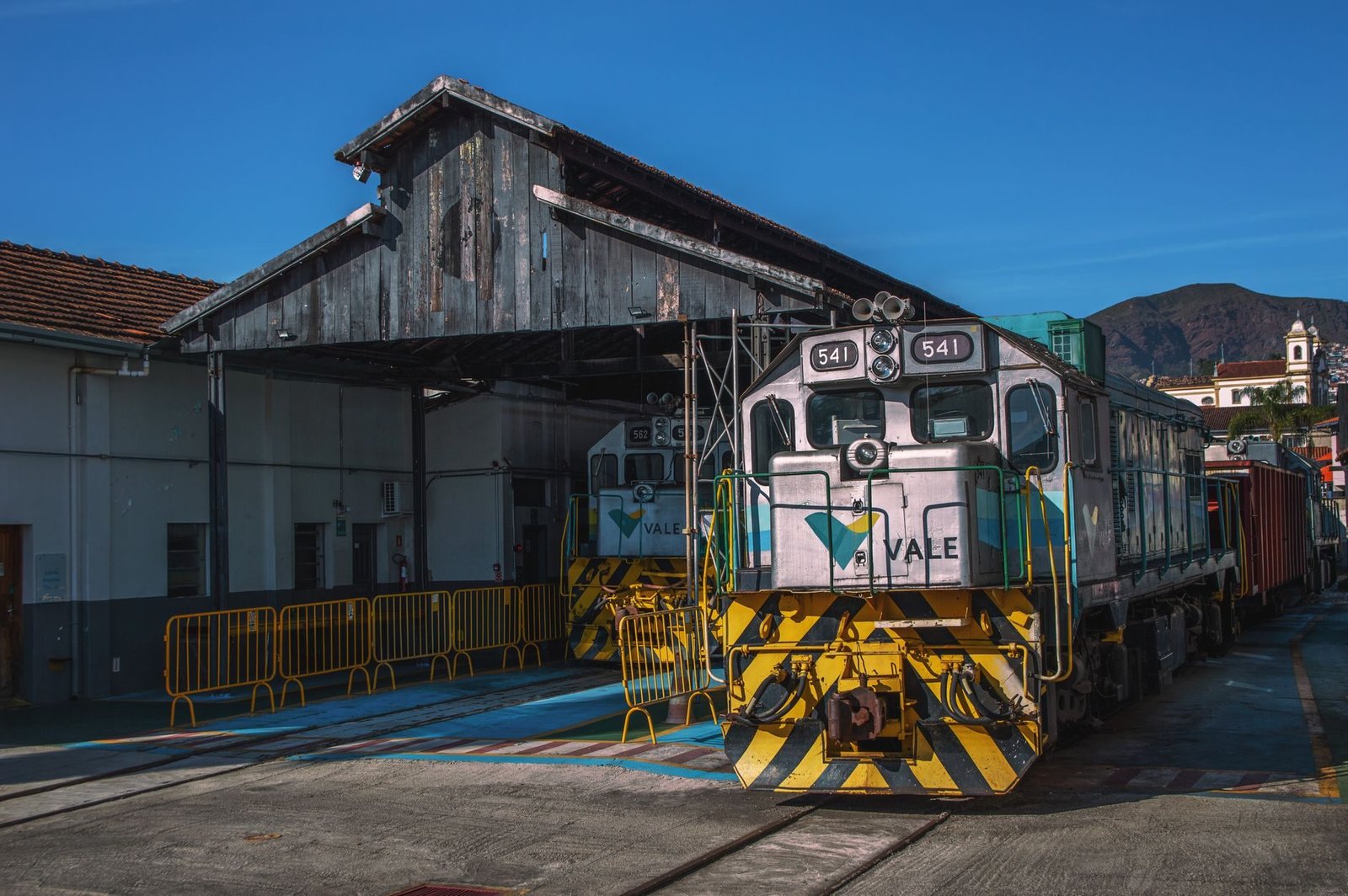 Maria Fumaça na Serra Gaúcha: Como Funciona o Passeio de Trem 3 Locomotiva histórica em estação de trem com céu azul e montanhas ao fundo