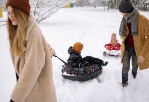 Família se divertindo com boias de neve em parque de inverno