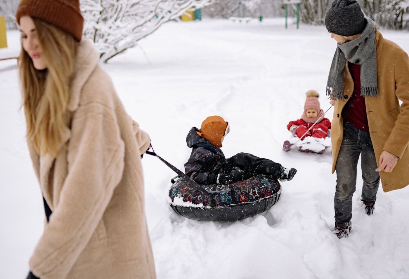 Snowland ou Mundo a Vapor: Qual Escolher com Crianças? 1 Família se divertindo com boias de neve em parque de inverno