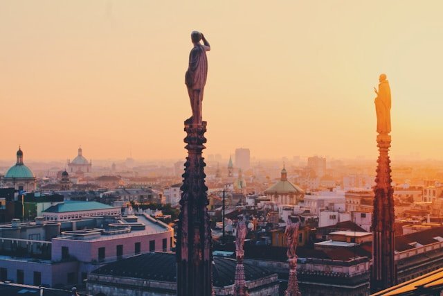 Duomo de Milão: Guia Completo para Sua Visita Inesquecível 5 Pico das torres do Duomo de Milano visto sob o por do sol.