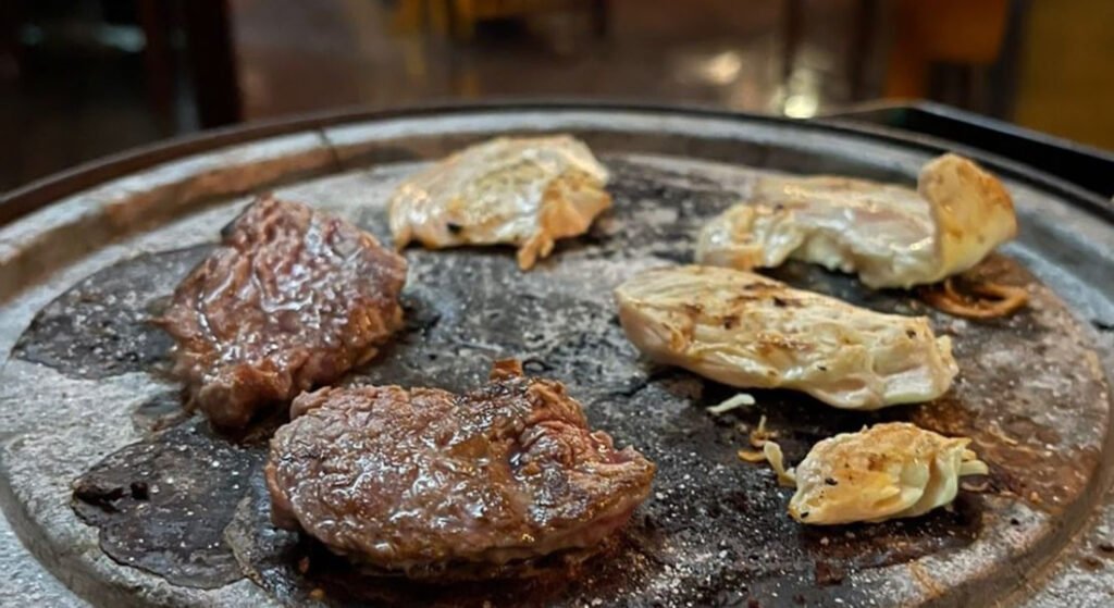 Onde comer fondue em Gramado? Confira essas opções incríveis! 2 Carnes assadas na tábua de ferro quente.