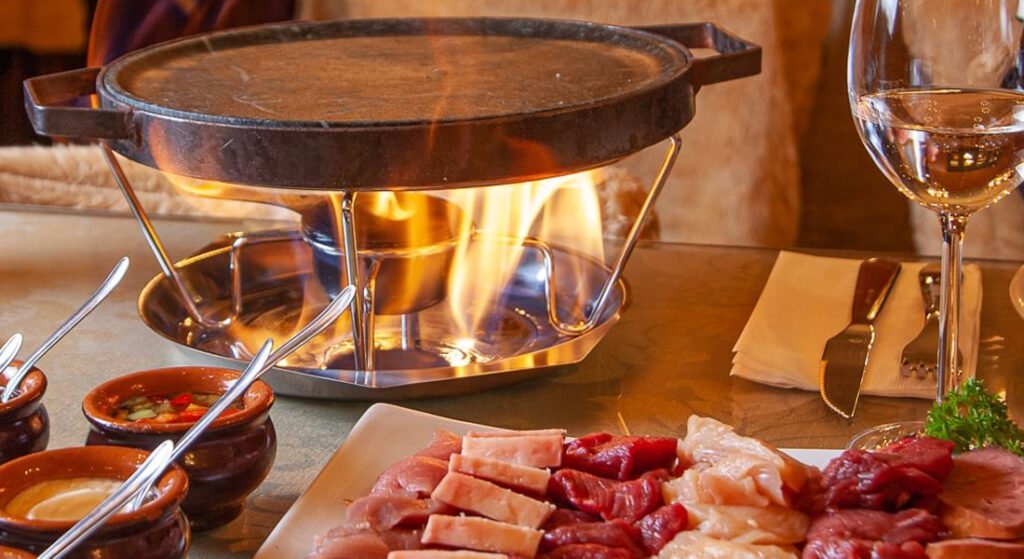 Gramado: Roteiro Perfeito com a Catedral de Pedra como Guia 6 Mesa de fondue, chapa de ferro quente e carnes a mesa