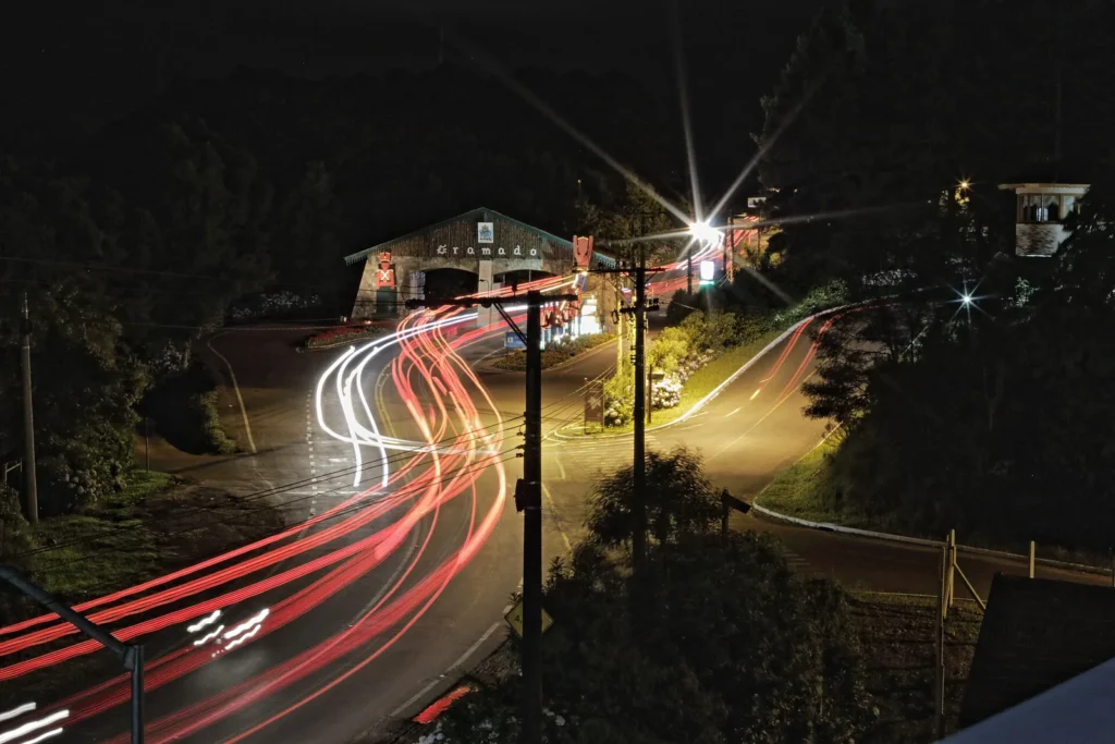 Gramado gratis: 1 día de itinerario sin pagar entrada 5 Pórtico de Gramado iluminado à noite com rastros de luz dos carros