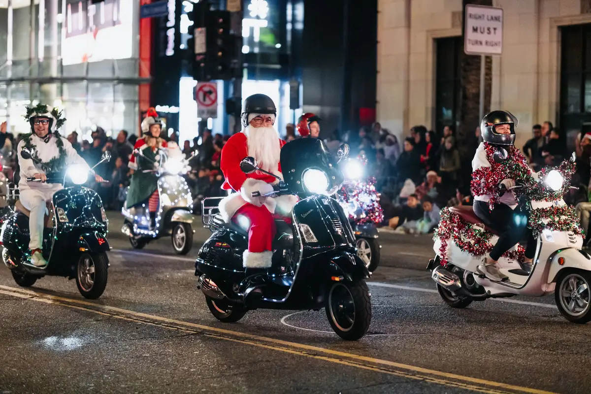 Natal Luz Gramado 2026: o Que Mudou Este Ano 2 Personagens fantasiados em desfile noturno de Natal