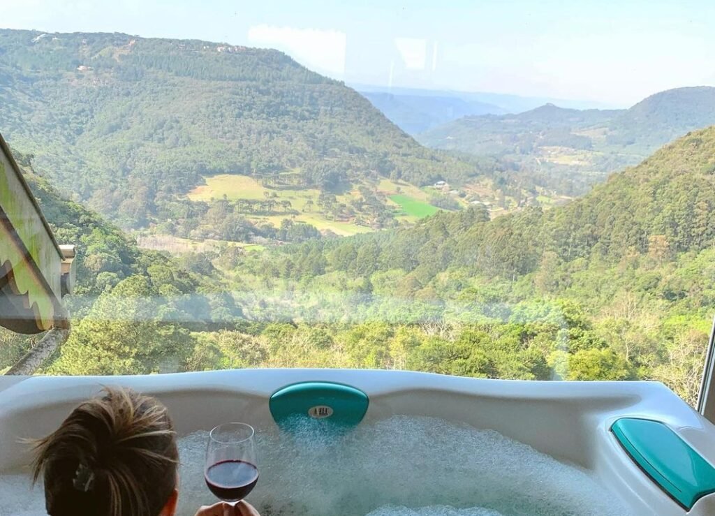 Hotel Villa Bella & Spa Gramado: Vista Deslumbrante e Conforto 2 Vista da janela do hotel, pessoa tomando vinho na banheira