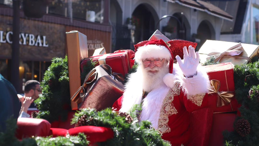 Atrações Gratuitas do Natal Luz de Gramado 3 Desfile parada de Natal em Gramado, papai noel acenando para as pessoas na rua.
