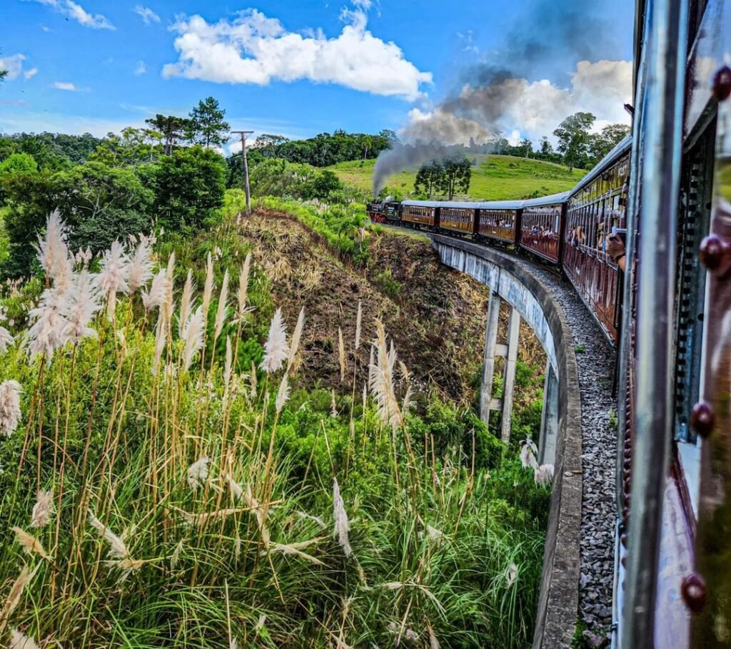 Passeio de Maria Fumaça em Gramado 2024 2 Foto do trem maria fumaça visto fazendo a curva, foto tirada da janela do trem