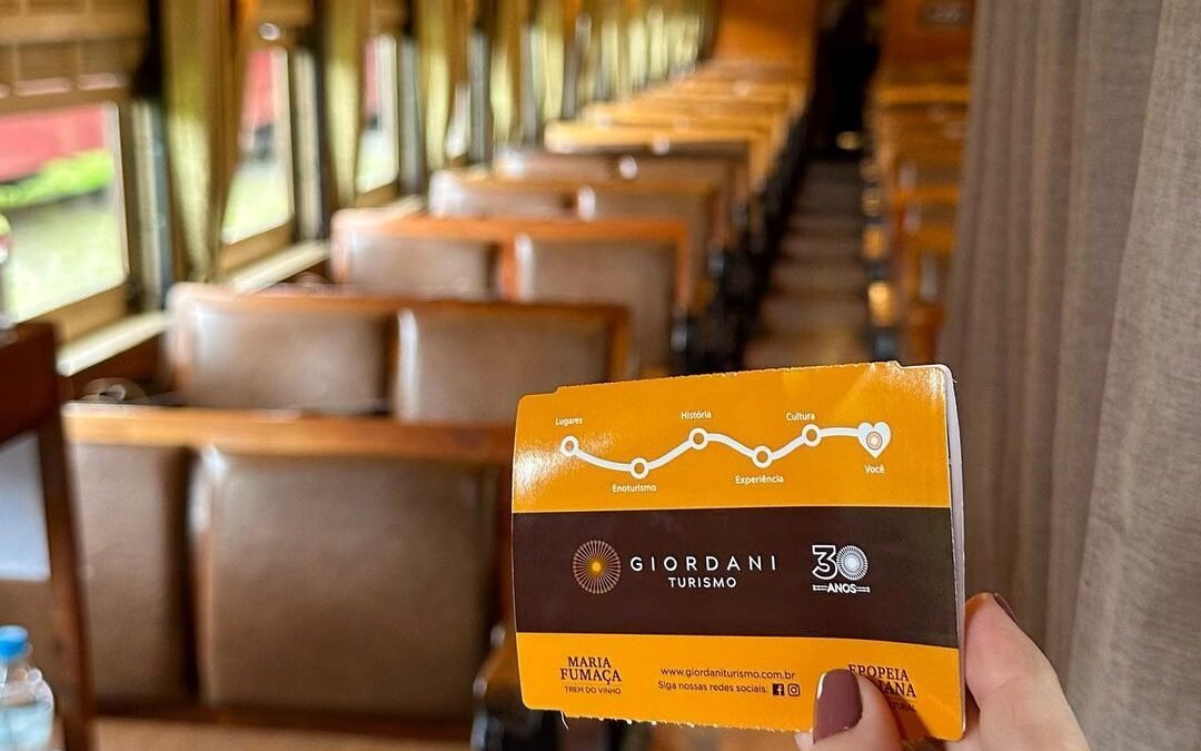 Aproveite o Frio em Gramado e Canela neste Inverno 7 Pessoa segurando bilhete de trem Maria Fumaraça em Bento Gonçalves. Interior do trem vazio.