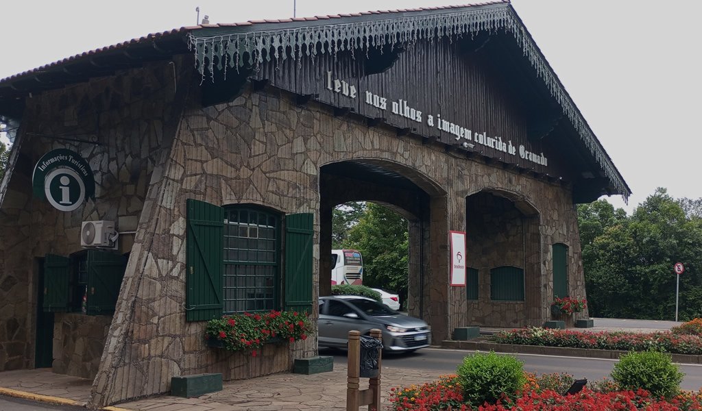 Os Pórticos de Gramado: Portais de Encanto e História 3 Carros passando por baixo do pórtico de Gramado. (sentido Nova Petrópolis)