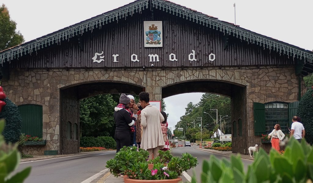 Os Pórticos de Gramado: Portais de Encanto e História 1 Pórtico de Gramado sentido Nova Petrópolis com turistas tirando fotos