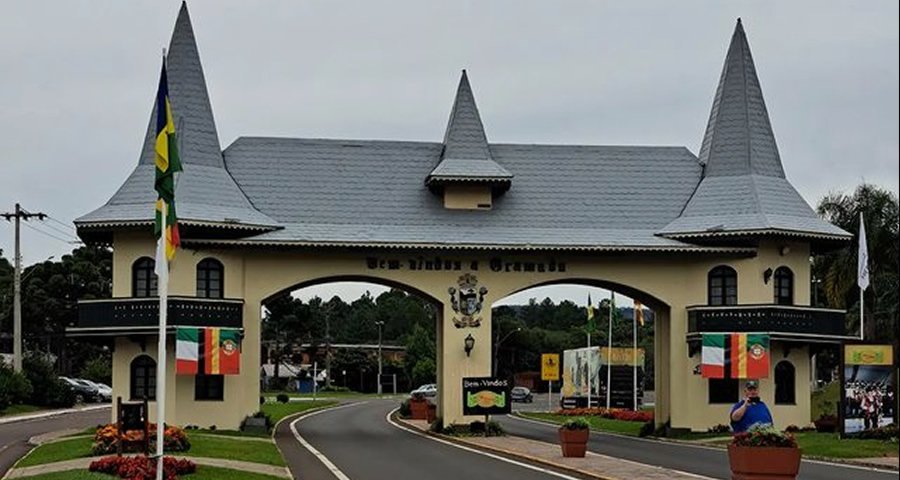 Os Pórticos de Gramado: Portais de Encanto e História 2 Pórtico via Taquara, construído em 1992, com bandeiras hasteadas.