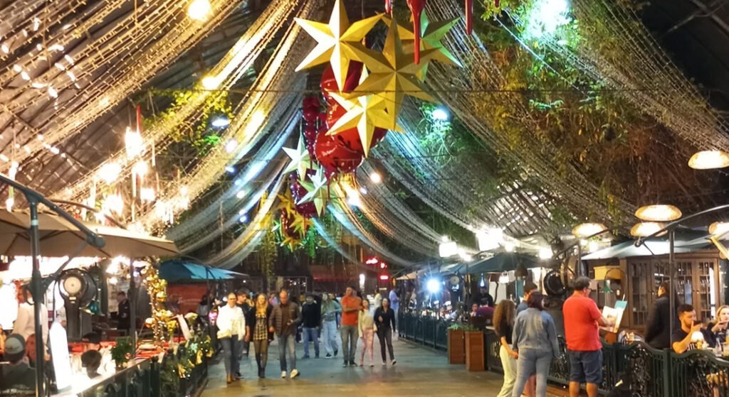 O que fazer em Gramado com chuva? 10 dicas turísticas 1 Foto da Rua Coberta de Granado com decoração de natal, pessoas nos restaurantes e caminhando pela rua