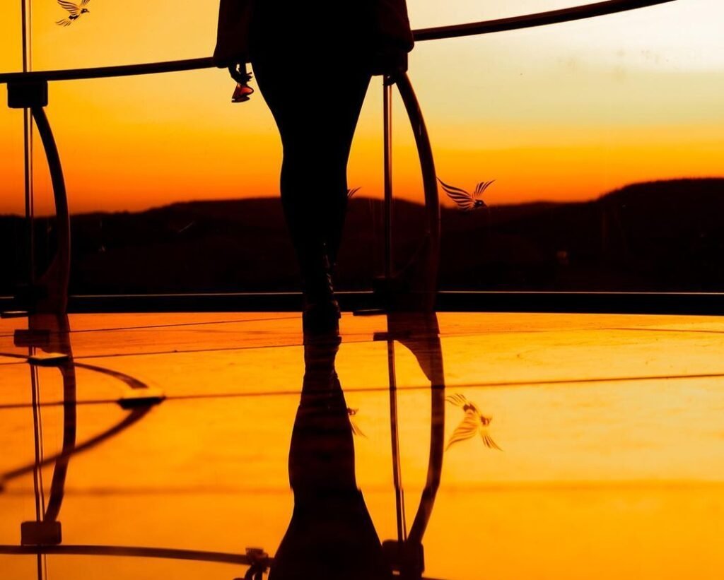 Skyglass Canela: Uma Aventura nas Alturas 1 Pôr do sol no skyglass Canela, mulher de costas olhando o sol ser pôr
