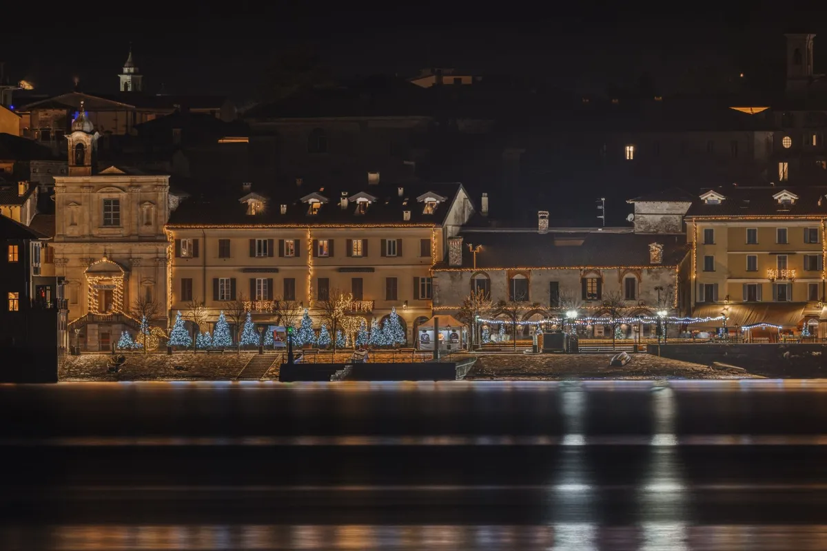 Nativitaten Gramado 2026: ingressos, preços e horário 2 Luzes de Natal refletidas na água à noite, no clima do espetáculo Nativitaten sobre o lago do Serra Park em Gramado