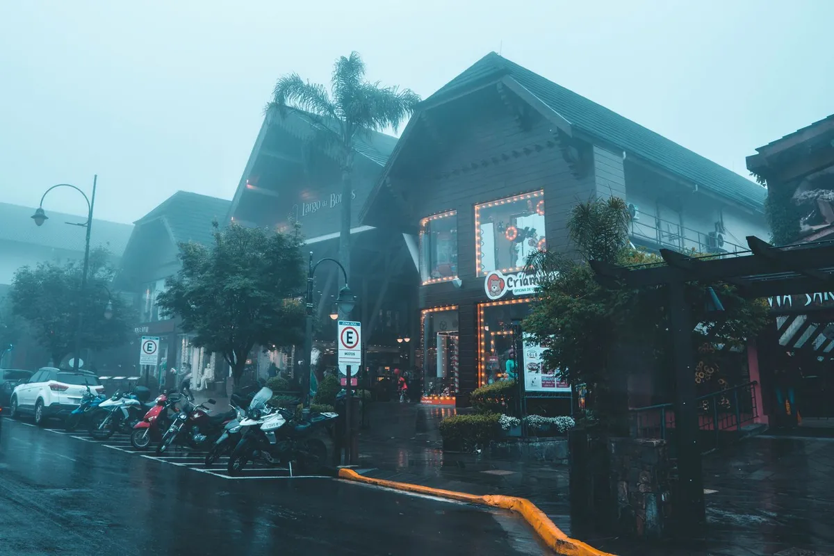 O que fazer em Gramado à noite: o que abre e o que é grátis 3 Rua molhada de Gramado em um dia de chuva e neblina, com motos estacionadas